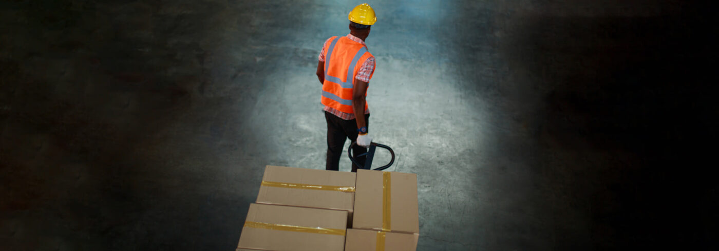 warehouse worker pulling a skid trolley